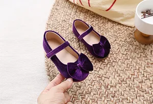 Detail van paars fluwelen meisjes prinsessenschoenen met grote strik en zijdeglans
