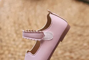 Detail von rosa Mary-Jane-Schuhen mit gewellten Riemen und feinen Nähten auf Leder