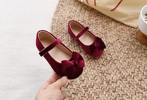 Detail van bordeauxrode fluwelen Mary Jane schoenen voor meisjes met strik en bandje