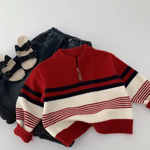 Flat lay of striped kids knit sweater with half-zip collar and denim pants set