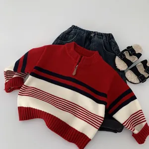 Detailed flat lay of striped knit sweater with zipper collar, denim pants, and sandals