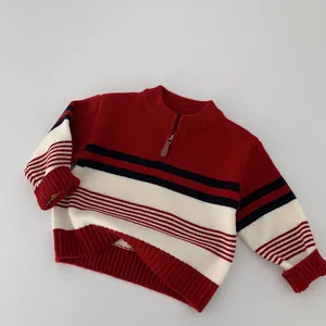 Detail of red striped kids sweater featuring half-zip collar and ribbed knit cuffs