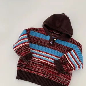 Detail of hooded striped knit sweater with Nordic geometric pattern and ribbed cuffs