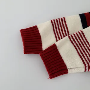 Detailed macro view of striped knit sweater cuff with red ribbed texture and navy stripes