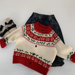 Detailed flat lay of children's knit cardigan with festive snowflake pattern and buttons