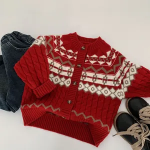 Detail showing the red cable knit texture and Fair Isle patterns on the kid cardigan