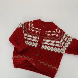 Close-up of red cable knit cardigan with traditional jacquard patterns and toggle buttons