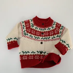 Detail of children's knit cardigan featuring festive snowflake patterns and ribbed cuffs