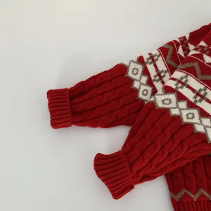 Macro detail of red cable knit sleeve and Fair Isle geometric patterns on kids sweater