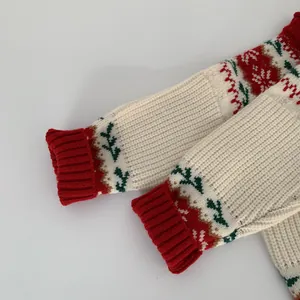 Detail of red ribbed cuffs and festive snowflake knit pattern on a beige sweater