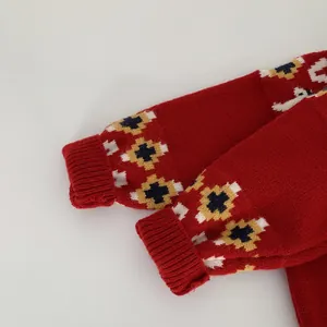 Dettaglio manica maglione rosso in maglia con motivi jacquard e polsini a coste