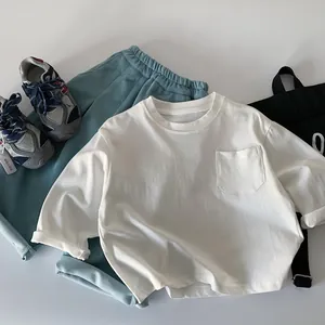 Detailed flat lay of white long sleeve cotton T-shirt and teal pants casual outfit
