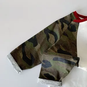 Close-up of kids raglan shirt featuring camouflage sleeves and red ribbed neckline