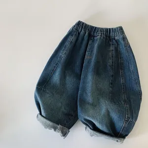 Dettaglio di jeans per bambini blu lavato con vita elastica e risvolti sulle gambe
