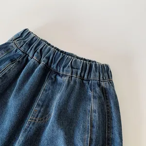 Dettaglio dei jeans blu scuro con elastico in vita e cuciture per pantaloni da bambino