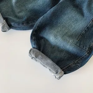 Dettaglio dell'orlo risvoltato e della trama saia sui jeans in denim per bambini