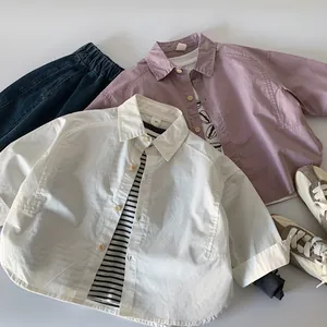 Flat lay of boys' white and pink long-sleeve shirts with blue jeans and sneakers