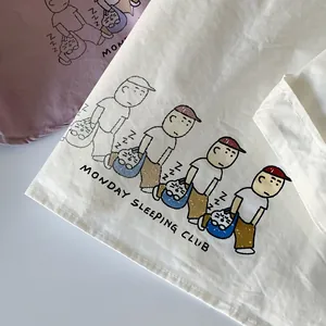 Detail of cotton shirt fabric with Monday Sleeping Club cartoon print and soft texture