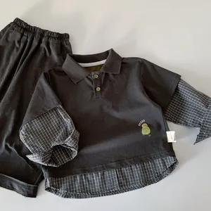 Detail of boys' polo sweatshirt with checkered faux two-piece hem and bird print