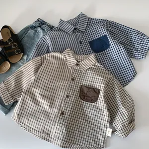 Flat lay of boys' striped and plaid patchwork shirts in blue-grey and beige shades