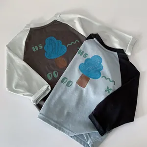 Close-up of cotton boys' long-sleeve raglan t-shirts with hand-drawn tree and letter prints