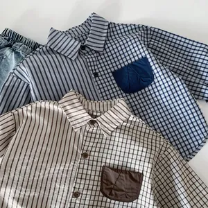 Detail view of boy's striped and checkered patchwork shirts with front pockets