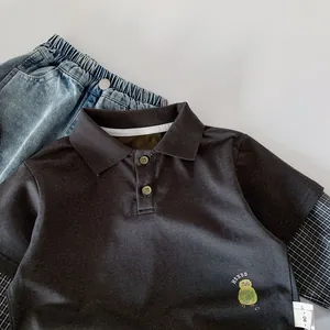 Detail of boys' polo shirt with owl embroidery and denim jeans with elastic waist