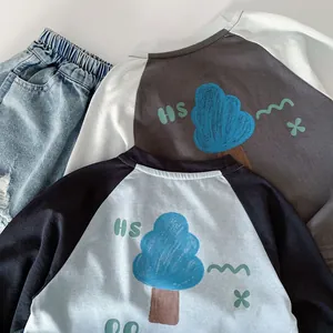 Detailed view of hand-drawn blue tree graphics and letters on boys' cotton long sleeve shirts