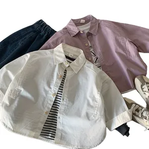 Flat lay of cotton shirts and blue jeans for toddler boys in beige and greyish purple