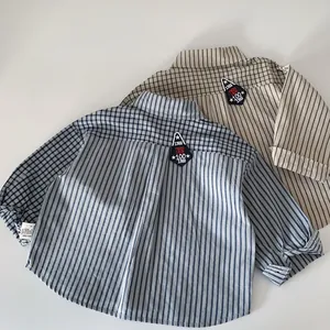 Detail of embroidered patch and stitching on striped and plaid cotton boy's shirts