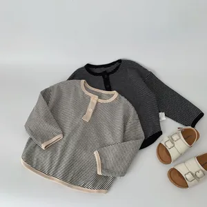 Detail view of boys' striped long-sleeve Henley shirts and white buckle cork sandals
