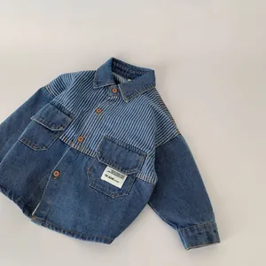 Detail of color-block denim shirt for boys with striped yoke and flap pockets