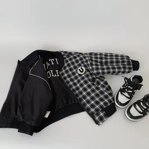 Detail of boys' black and white checkered reversible jacket with embroidered patch