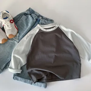 Flat lay of boy's cotton raglan long sleeve shirt with denim jeans and sneakers
