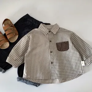 Flat lay of boy shirt with contrast patchwork stripes and plaids with navy jeans