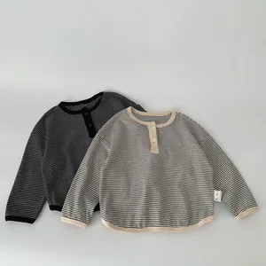 Detail of boys striped cotton long sleeve shirts with Henley neck and button closure