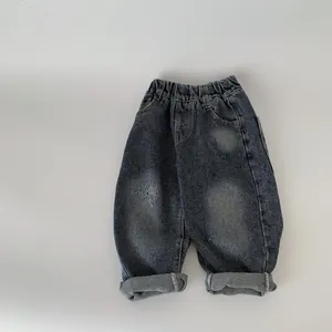 Classic boys denim pants with distressed details and elastic waistband on white background