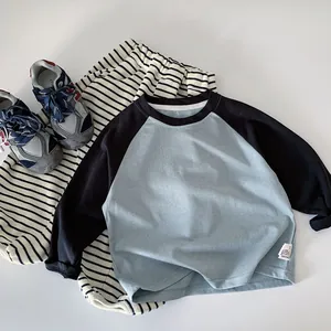 Detail of boys raglan sleeve cotton T-shirt and striped pants set on white background