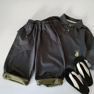 Detail of boys' polo shirt set featuring cartoon chick print and contrast cuff shorts