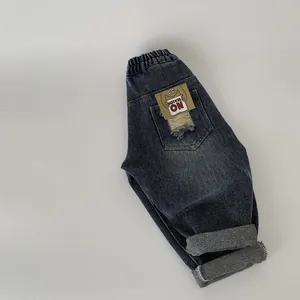 Detail of kids denim pants showing the elastic waist and 'NO REASON' pocket patch