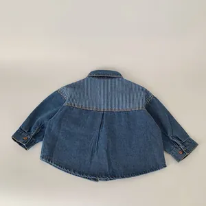 Detail of boys denim shirt featuring striped yoke patch and back pleat design