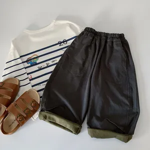 Detail of boys' striped long sleeve polo shirt and wide-leg pants with olive green cuffs
