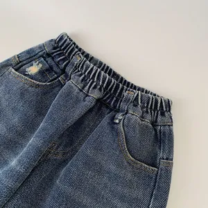 Detail of kids elastic waist denim jeans with side pockets and distressed rip design