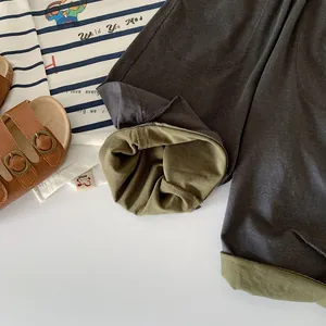 Close-up of boys' dark grey trousers with olive green lining and double-layered cuffs