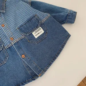 Detail of boys denim shirt with striped patchwork and vintage brown buttons close-up