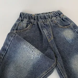 Close-up of boys' denim pants showing elastic waist, washed texture, and metallic rivets