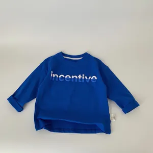 Detail of blue kids long sleeve T-shirt showing printed incentive letters and neck label