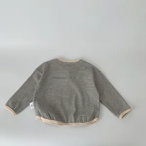 Detail view of boys long sleeve striped t-shirt with beige ribbed cuffs and hem finishing