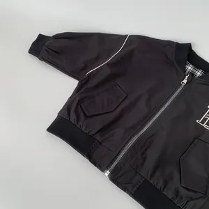 Detail of kids baseball jacket featuring metal zipper and plaid lining texture