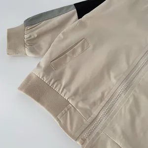 Detail of color-block jacket showing ribbed cuffs, flap pocket and zip closure